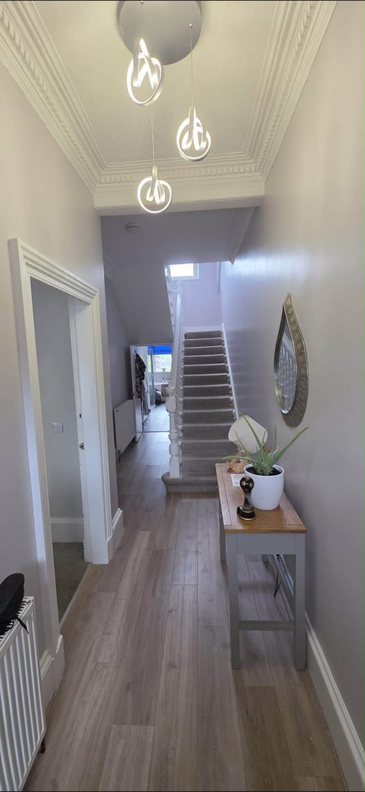 Painted hallway and staircase with grey walls, white joinery and pendant lights