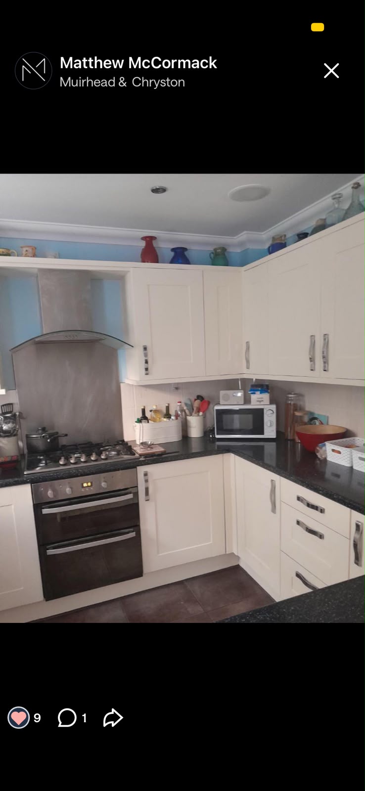 Cream painted kitchen cupboards with a blue wall above the worktop